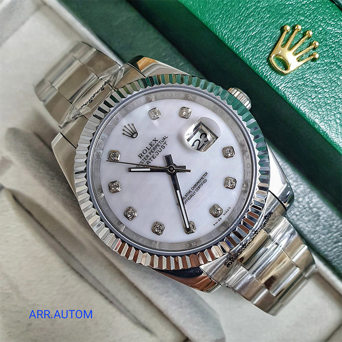 Reloj Rolex Oyster Perpetual Datejust con esfera blanca, 10 diamantes y bisel acanalado de acero inoxidable, con movimiento automático y resistencia al agua de hasta 100 metros.