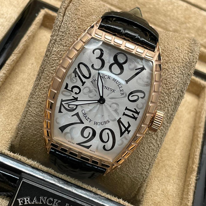 Franck Muller Geneve Crazy Hours, reloj de lujo con diseño único de números desordenados en una esfera plateada brillante, correa de cuero negro y elegante caja metálica.