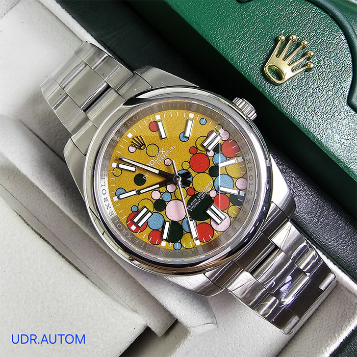 Reloj Rolex Oyster Perpetual Edición Limitada con esfera amarilla y diseño artístico en colores vibrantes, brazalete Oyster de acero inoxidable, con ventana de fecha a las 3 y resistencia al agua de hasta 100 metros.