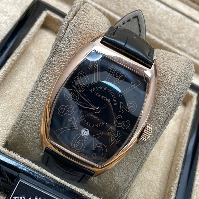 Franck Muller Geneve Casablanca con números grandes sobre esfera negra, elegante caja de acero inoxidable y correa de cuero negro.