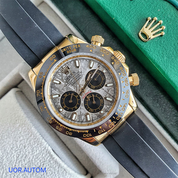 Reloj Rolex Oyster Perpetual Superlative Chronometer Daytona con esfera de meteorito y correa de caucho negra, diseño de lujo con detalles en oro y cronógrafos.