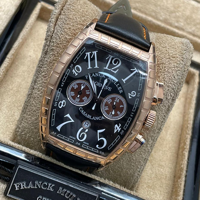 Franck Muller Geneve Casablanca con caja de acero dorado, esfera negra y detalles en rojo, con correa de cuero negro, un reloj elegante para ocasiones especiales.