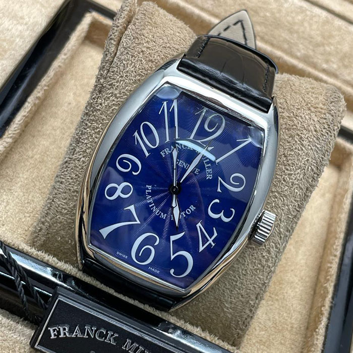 Franck Muller Geneve Platinum Rotor con caja de platino, esfera azul y números blancos, acompañado de una correa de cuero negro, un reloj elegante y exclusivo.