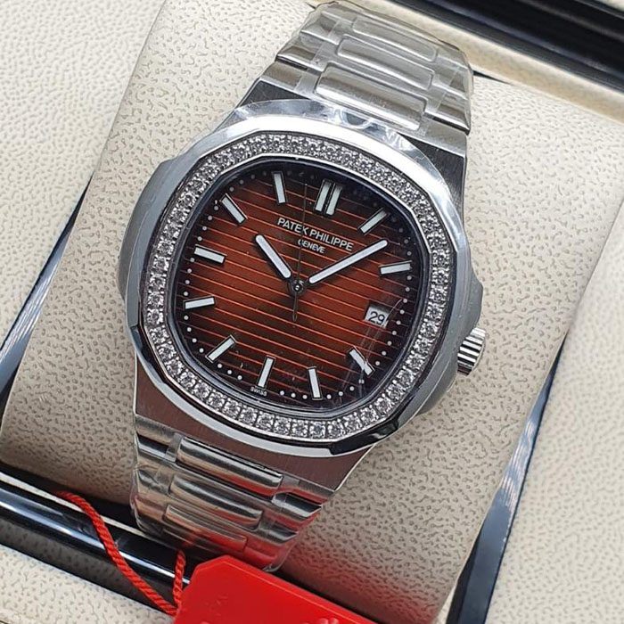 Reloj estilo Patek Philippe Geneva con bisel brillante de cristales y esfera marrón, diseño de 40mm con brazalete metálico.
