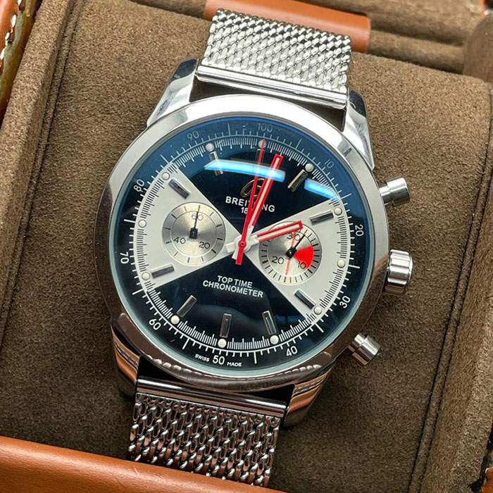Reloj Breitling Top Time Chronometer Mesh Edition con carátula negra, detalles en rojo y brazalete de malla metálica.
