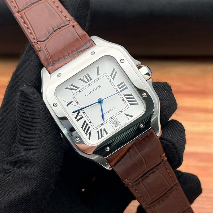 Cartier Santos Automático 38mm con caja de acero inoxidable, esfera plateada, correa de cuero marrón y detalles en azul.