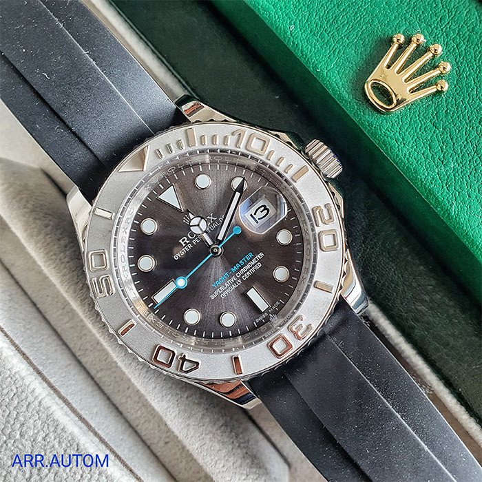 Rolex Yacht-Master con esfera gris y detalles en azul, correa de goma negra, y diseño elegante y deportivo. Ideal para quienes buscan una pieza sofisticada y funcional.