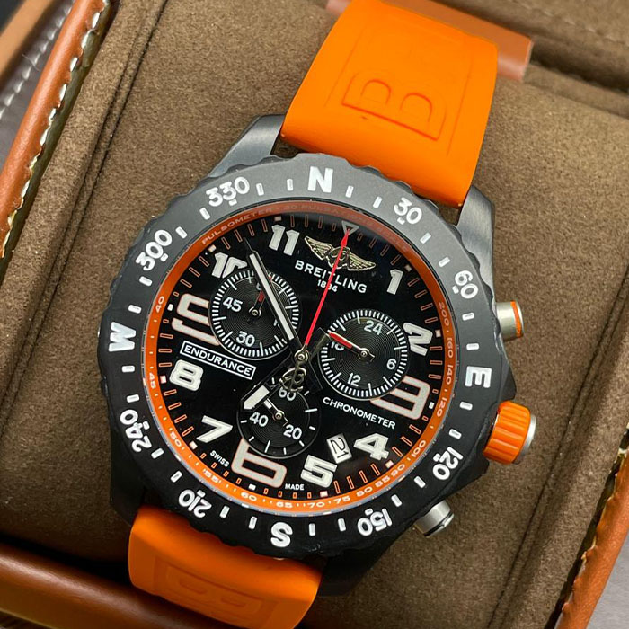 Reloj Breitling Endurance Chronometer con diseño deportivo, correa naranja y cronómetro de alta precisión.