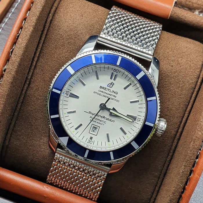 Reloj Breitling Superocean Chronometer Automatic con diseño de malla metálica y bisel azul, perfecto para un look elegante y sofisticado.